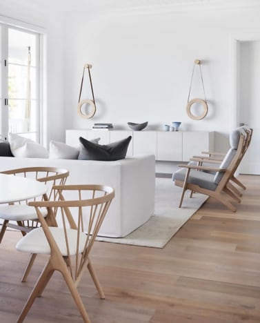 Scandinavian, modern home interior, white walls and ceiling, white sofa and cabinets, wood framed chairs